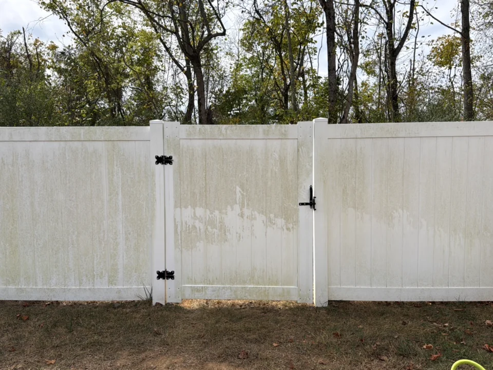 Green algae washed off a white vinyl fence — before cleaning in Spring Hill, TN